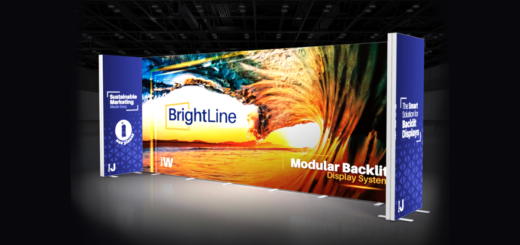 BrightLine modular backlit display wall at a trade show with blue branding panels on the sides, sunset graphic in the center.